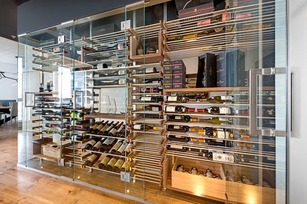 Agencement moderne de cave à vin avec étagères et casiers en bois et métal pour un rangement optimal des bouteilles.