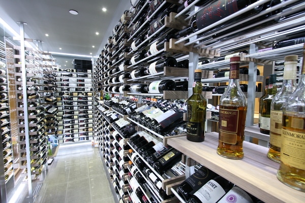 "Agencement moderne de cave à vin avec étagères et casiers en bois et métal pour un rangement optimal des bouteilles."