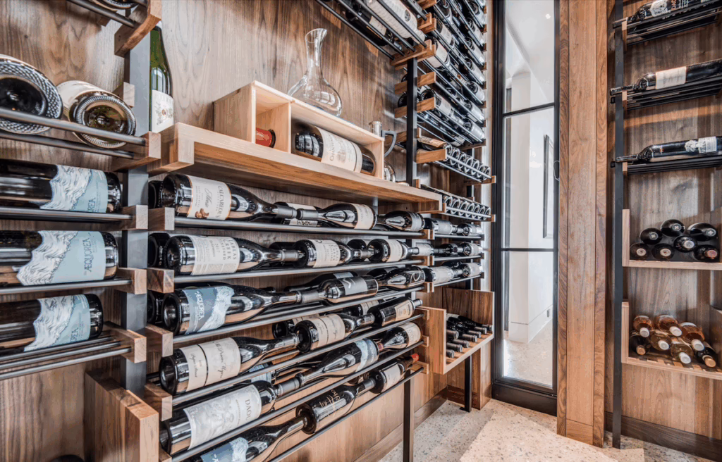 Agencement moderne de cave à vin avec étagères et casiers en bois et métal pour un rangement optimal des bouteilles.